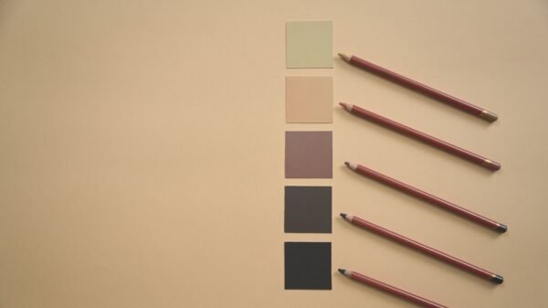 Flat lay of colored pencils and earthy tone swatches on a beige background, perfect for art and design contexts.