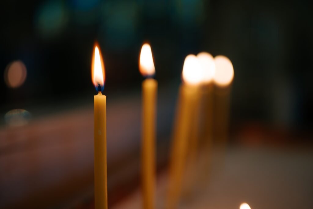 Close-up of lit candles creating a serene atmosphere with soft bokeh in the background.